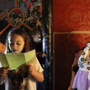 Dieťa číta indície a hľadá riešenie escape room úlohy